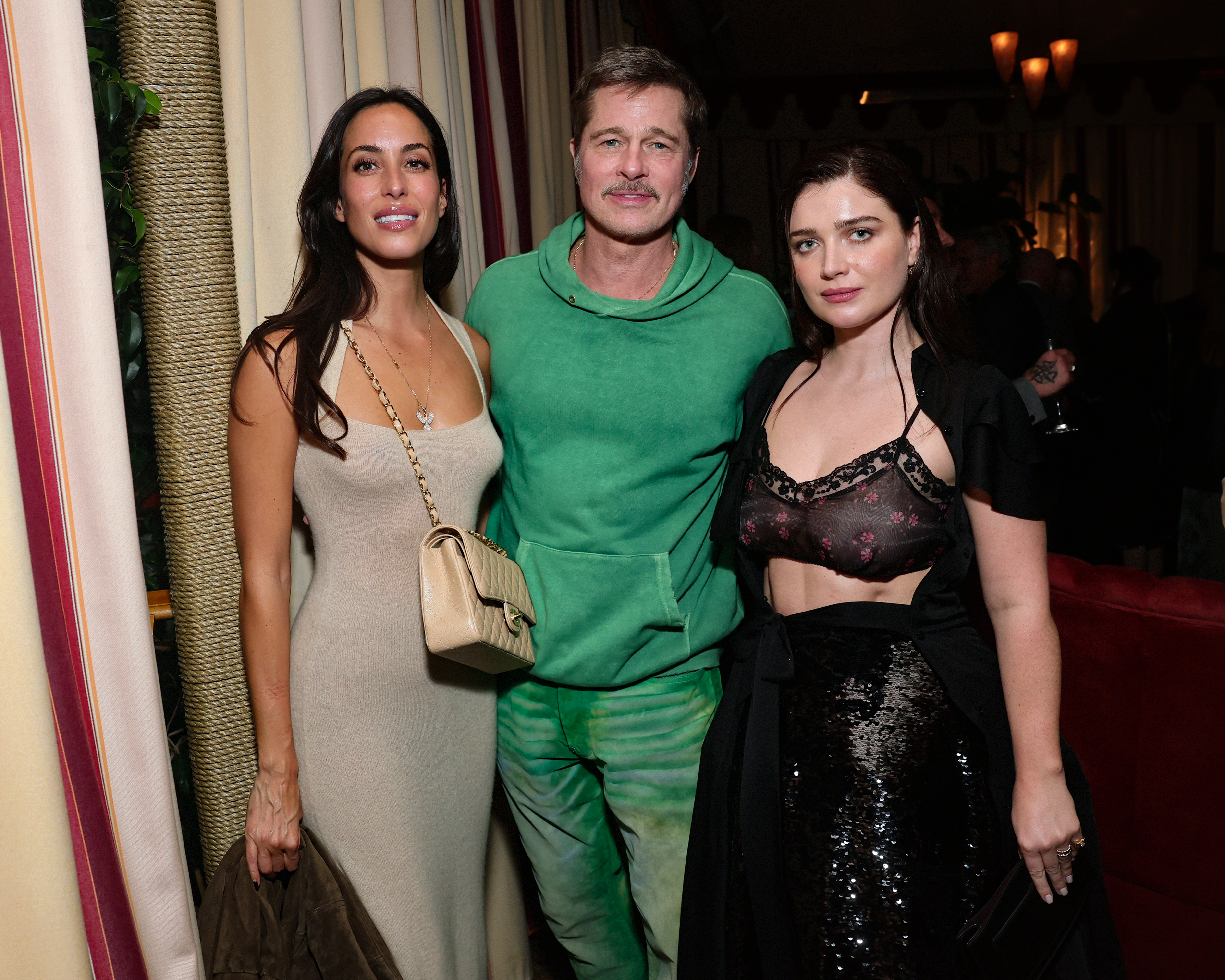 Brad Pitt, Ines de Ramon, and Eve Hewson posing together at the Netflix Jay Kelly premiere at Chateau Marmont
