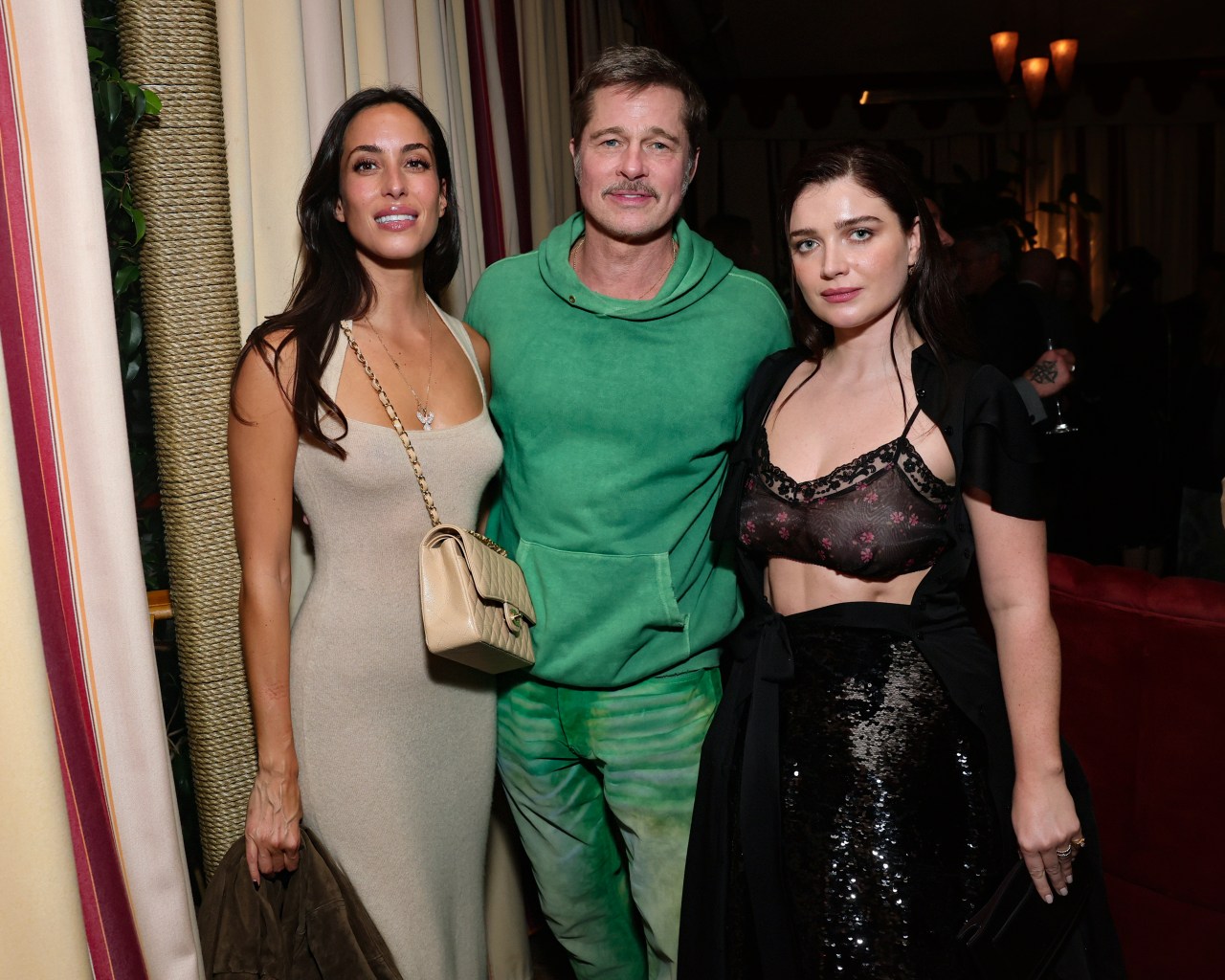 Brad Pitt, Ines de Ramon, and Eve Hewson posing together at the Netflix Jay Kelly premiere at Chateau Marmont