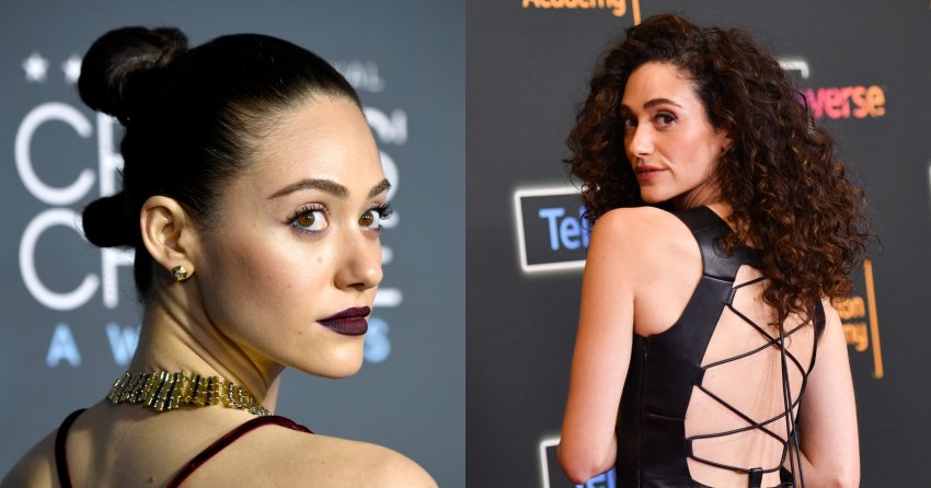 Emmy Rossum in a backless burgundy gown and gold choker, hair in a top bun, looking back over her shoulder at the Critics' Choice Awards.