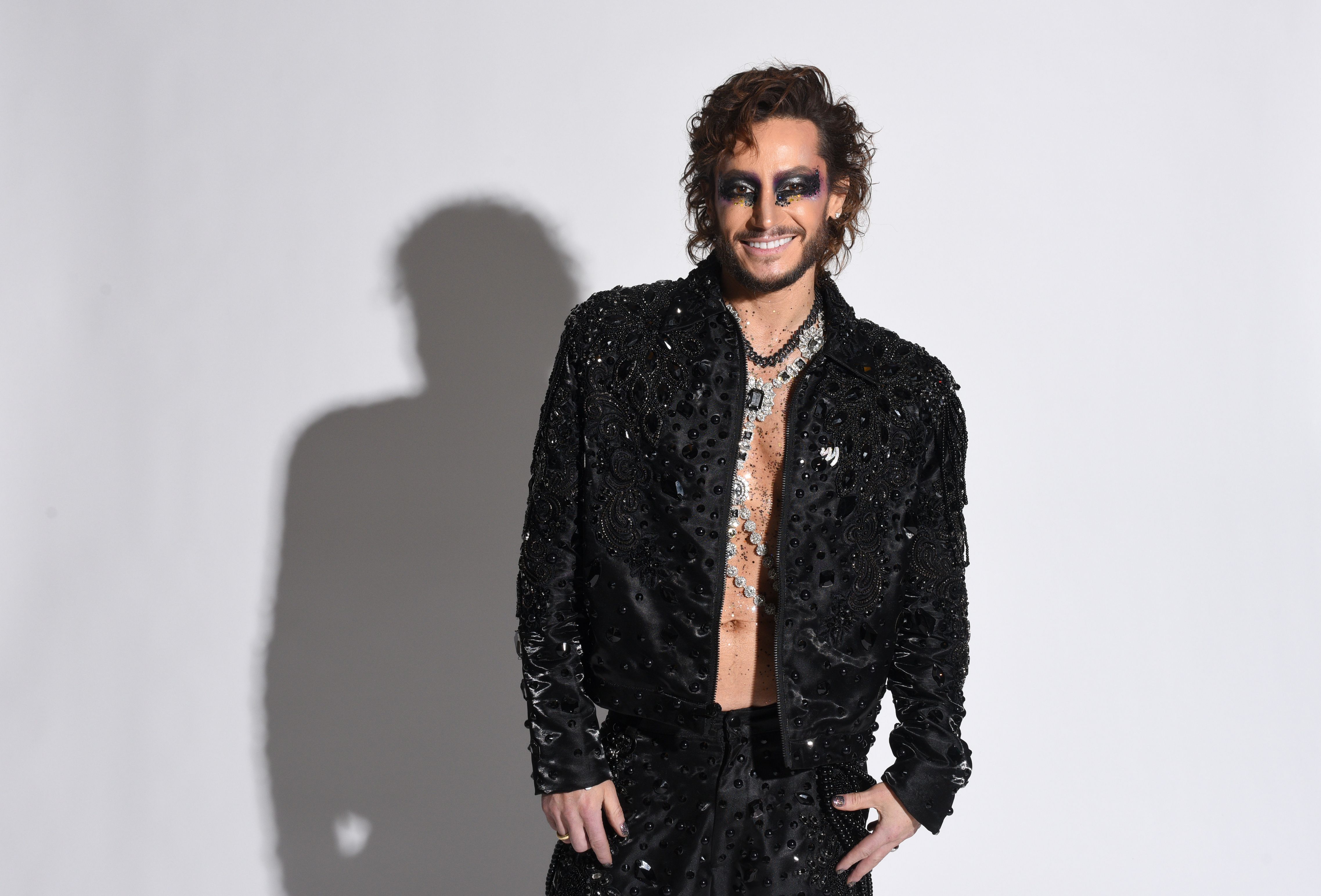 Frankie Grande in a black embellished open jacket with dramatic eye makeup and silver necklaces at the 2026 GLAAD Media Awards portrait studio.