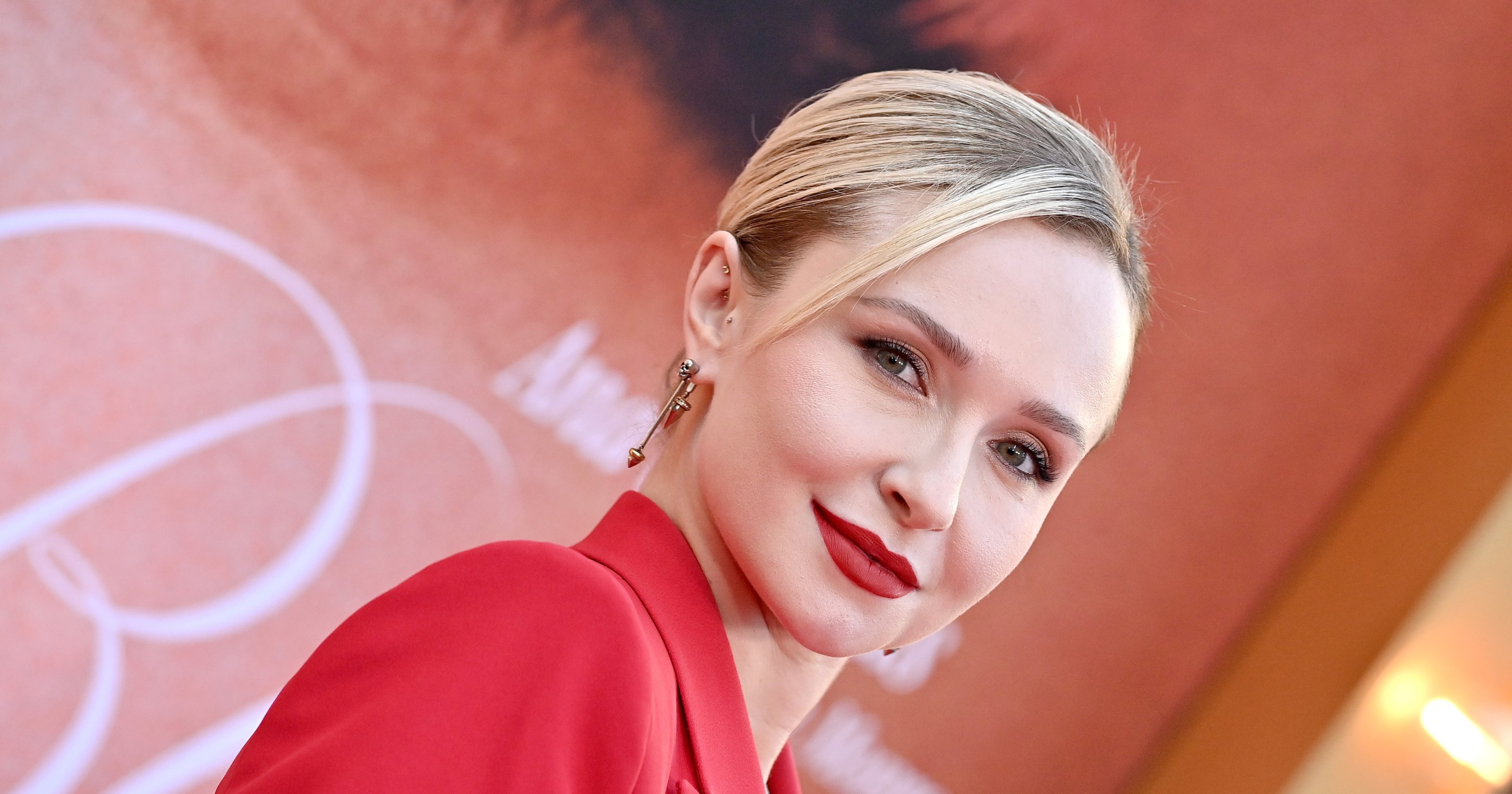 Hayden Panettiere in a red blazer with slicked-back blonde hair and red lipstick at a movie premiere in Hollywood.