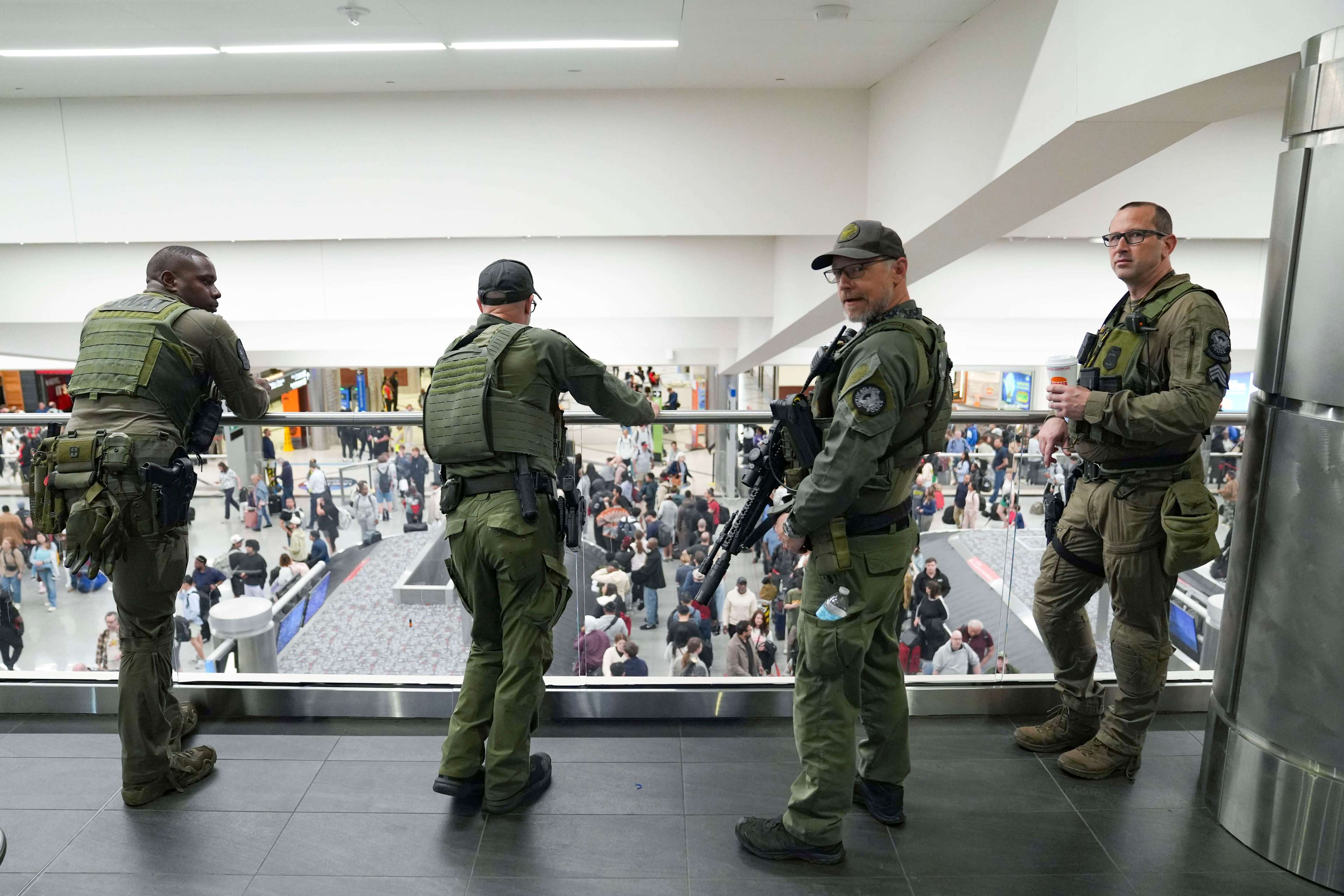 Atlanta Police officers watch as travelers stand in long lines at Hartsfield-Jackson International Airport in Atlanta, Georgia.