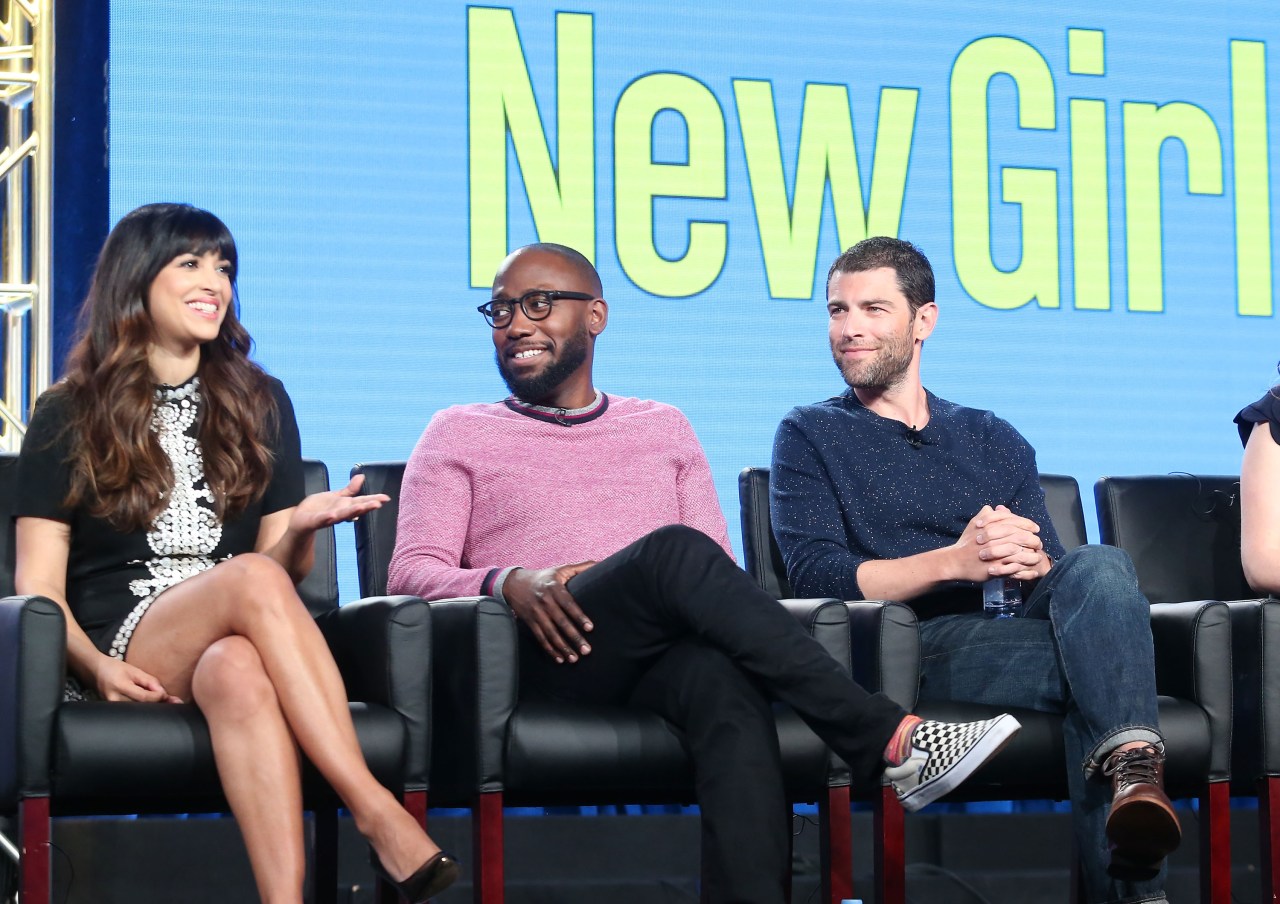 Hannah Simone, Lamorne Morris, and Max Greenfield seated on stage at the 2018 Winter TCA Press Tour in front of a New Girl backdrop.