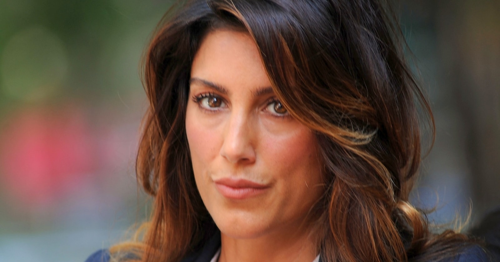 Jennifer Esposito in a black strapless dress with pearl drop earrings at a red carpet event in Los Angeles.
