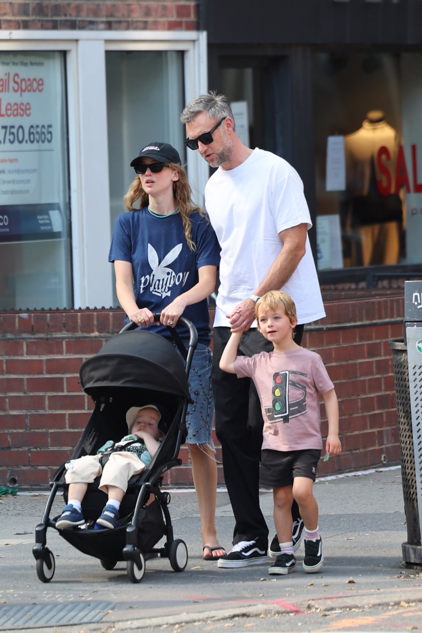 Jennifer Lawrence in a Playboy t-shirt, denim shorts, and slippers walking with Cooke Maroney and their children in the West Village