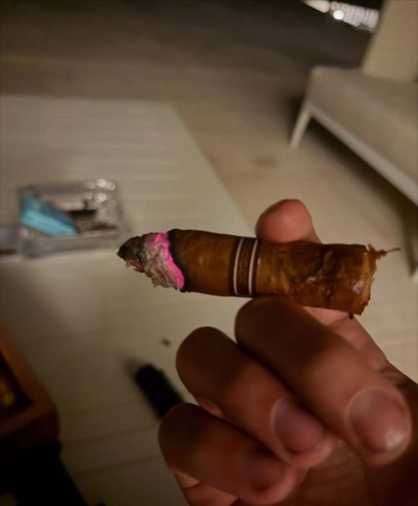 Justin Bieber holding a cigar in a close-up selfie