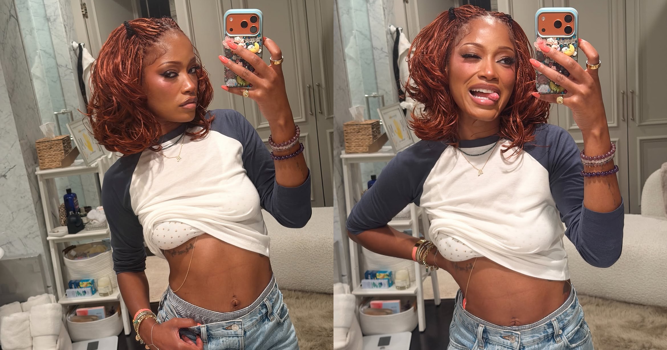 Woman with auburn braids takes a mirror selfie in a bathroom, wearing a cropped baseball tee and low-rise denim shorts.
