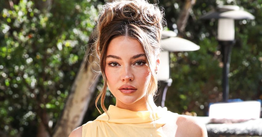 Madelyn Cline in a sleeveless yellow draped top and sheer pastel floral skirt at an outdoor event in Los Angeles.