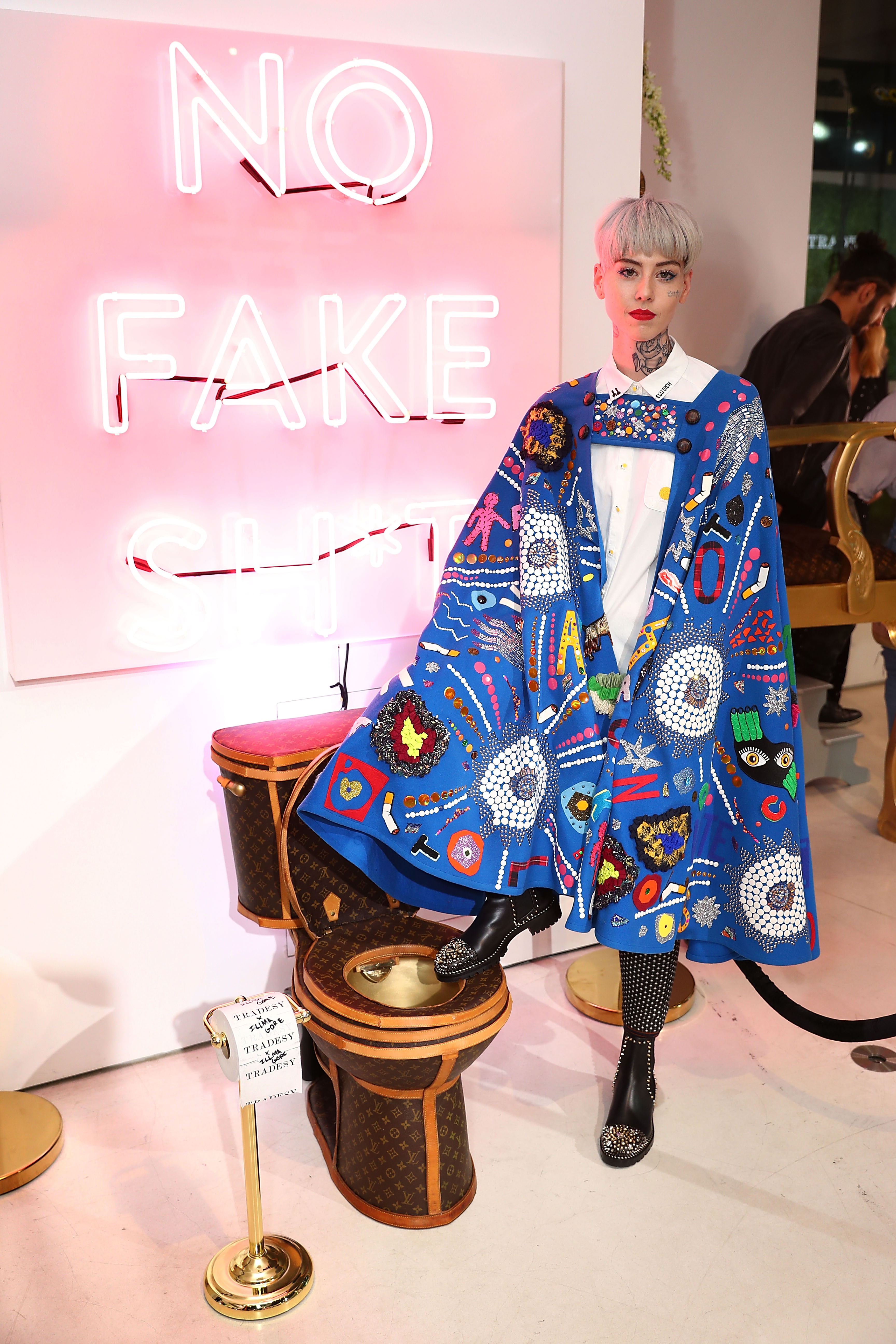 Artist Illma Gore posing next to a $100,000 Louis Vuitton-branded toilet at the Tradesy Showroom Opening in Santa Monica