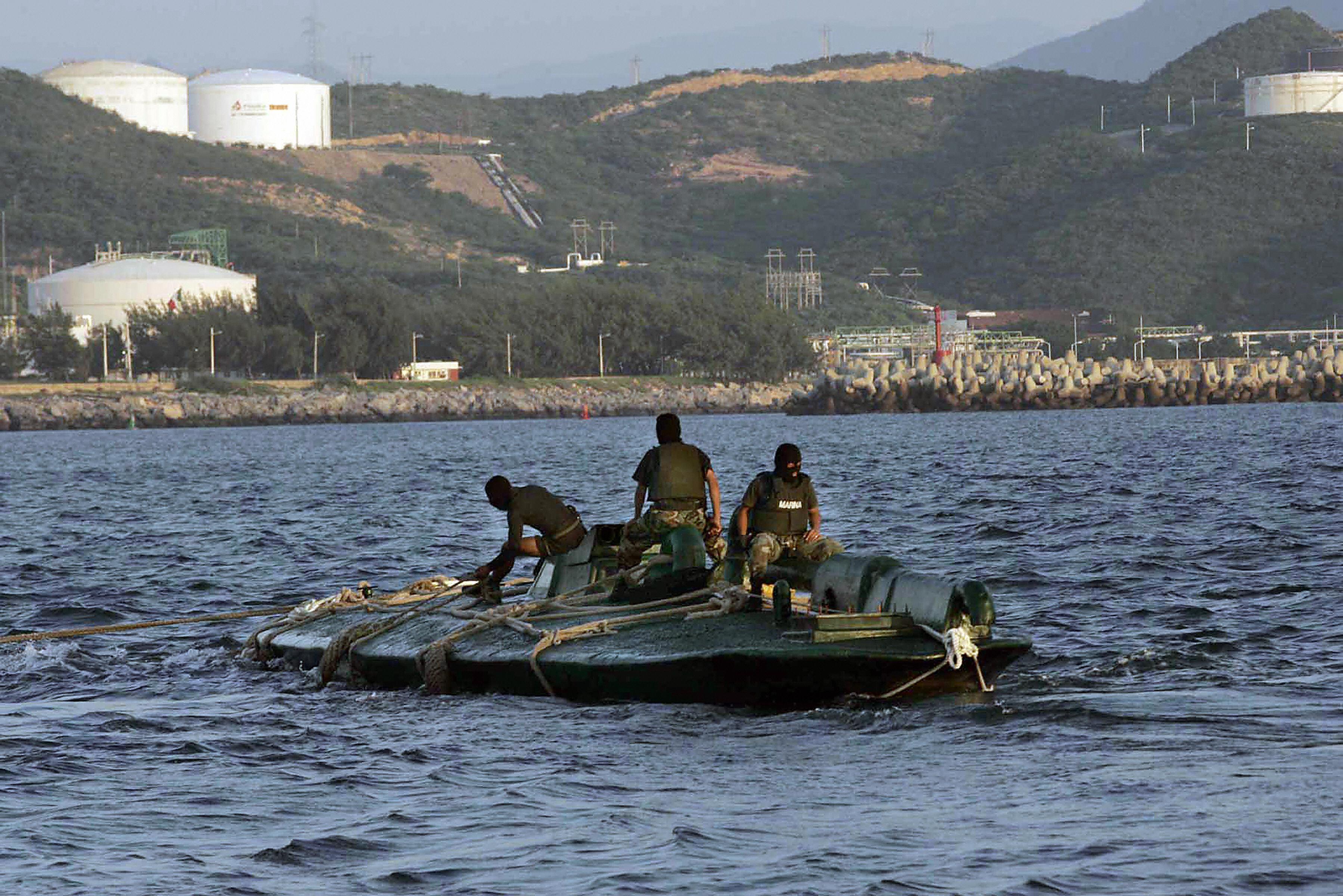 Mexican Navy personnel inspecting a seized narco-submarine at a port in Salina Cruz, Oaxaca