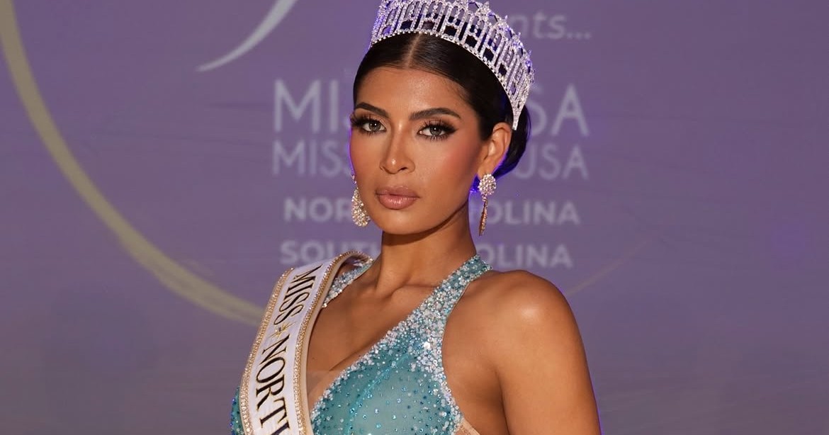 Woman in a teal beaded gown, crown, and Miss North Carolina USA sash posing on stage at a Miss USA pageant event.