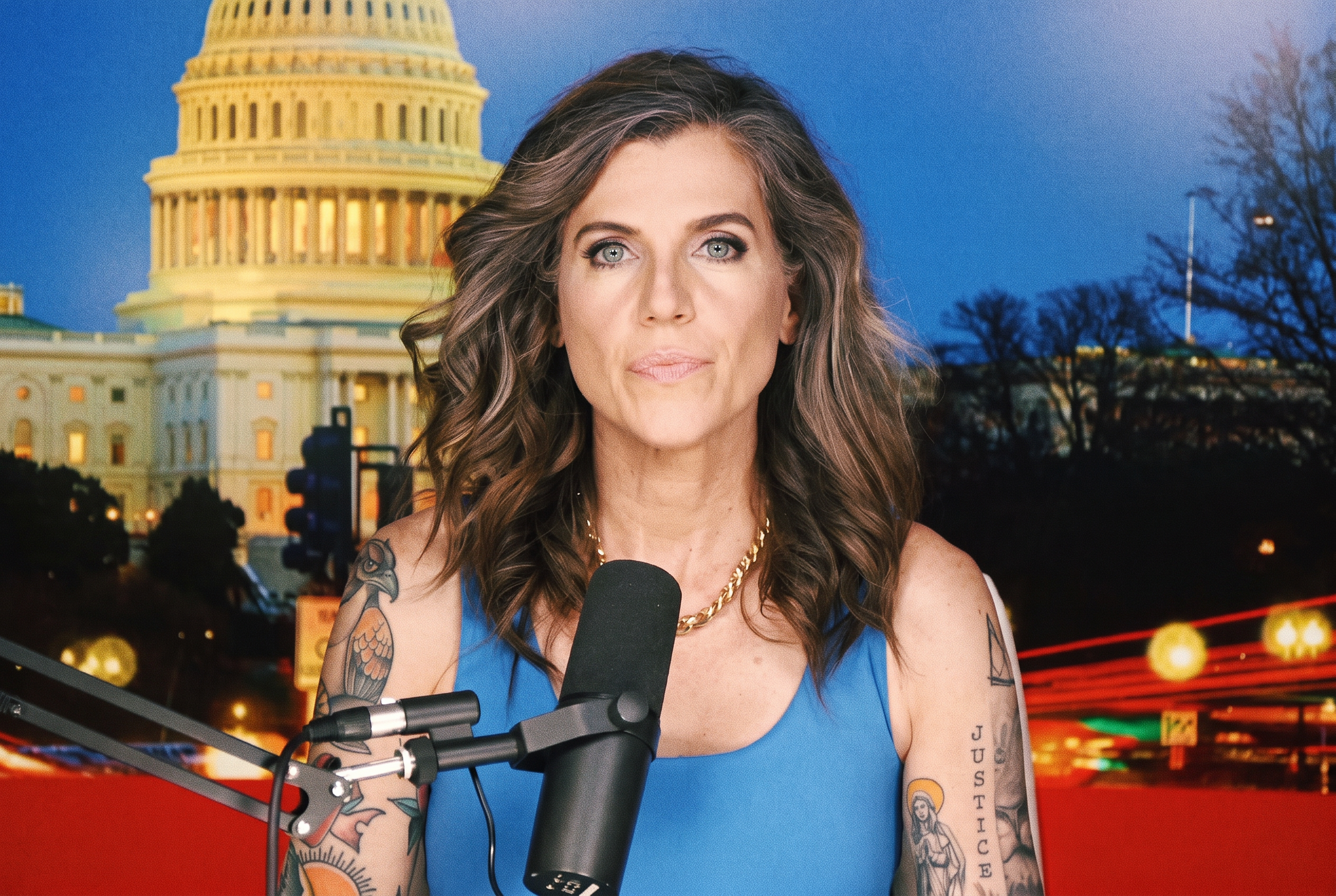 Woman with brown wavy hair and tattoos covering both arms sits before a podcast mic, with a U.S. Capitol building backdrop behind her.