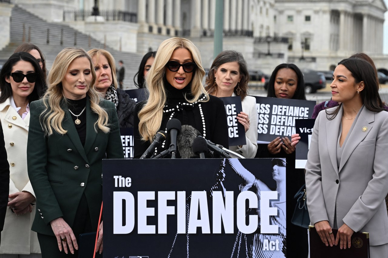 Paris Hilton speaking at a Capitol Hill press event alongside Representatives Alexandria Ocasio-Cortez and Laurel Lee in support of the DEFIANCE Act