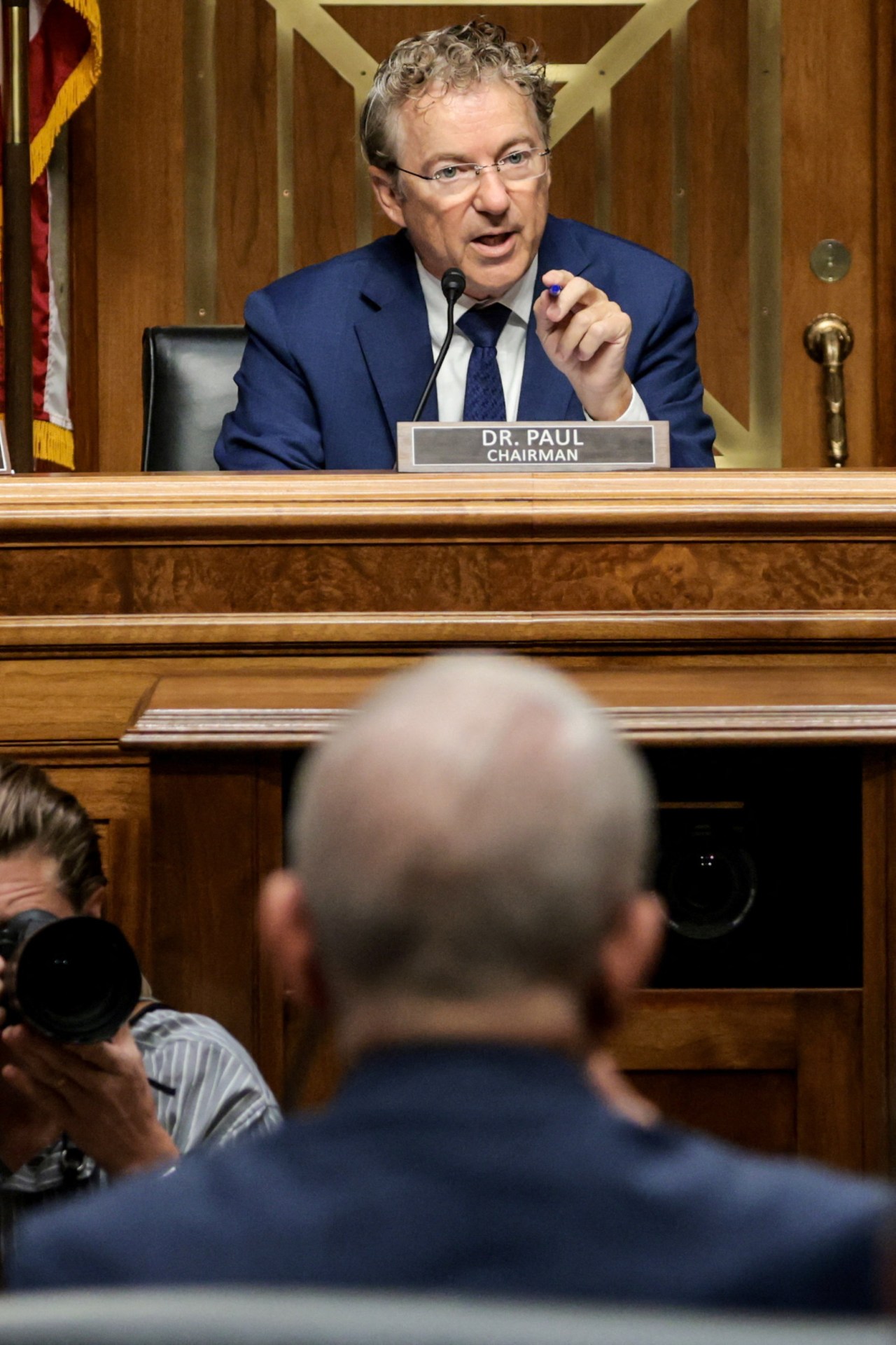 Anthony Fauci seated at a Senate committee hearing on Capitol Hill as Rand Paul speaks