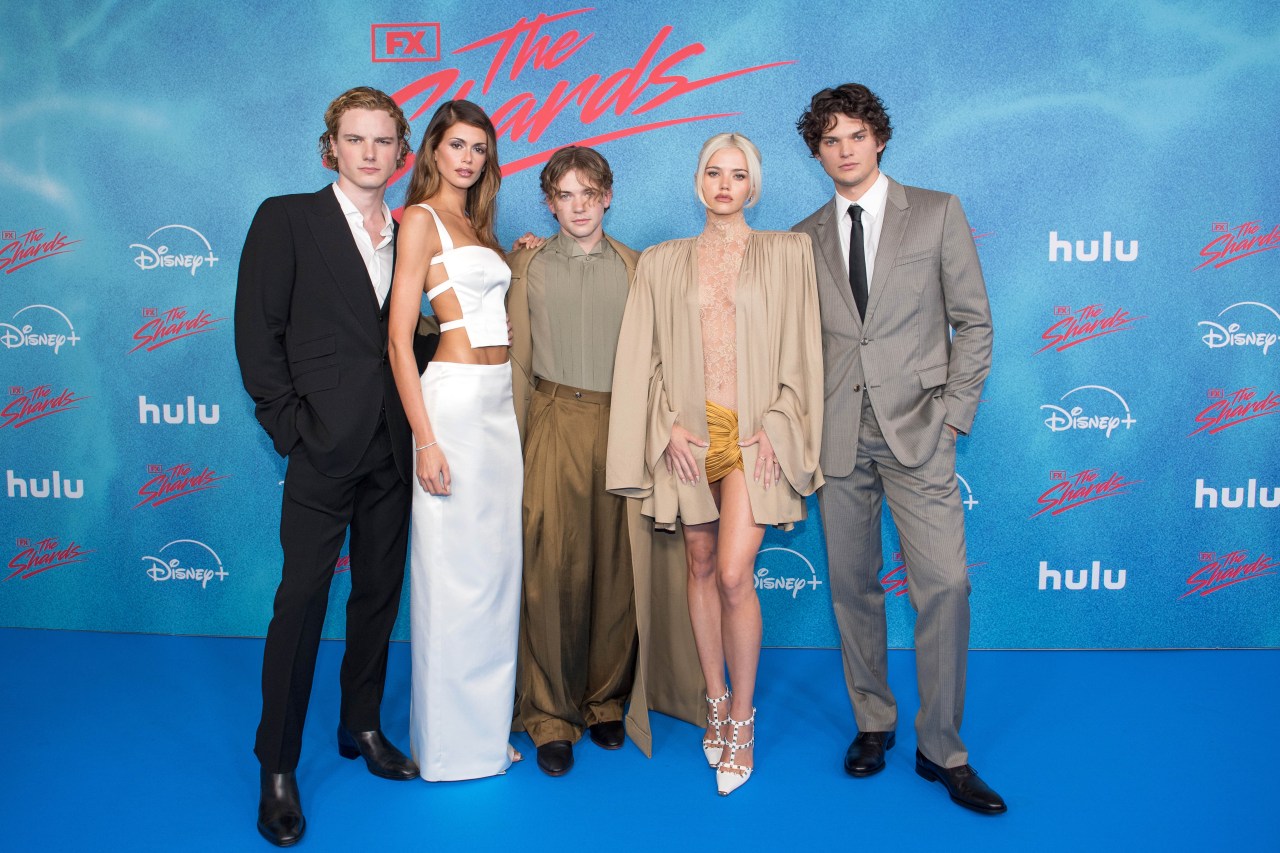 Five young cast members posing together at The Shards Berlin premiere photocall in front of a blue step-and-repeat banner with Hulu and Disney+ logos.