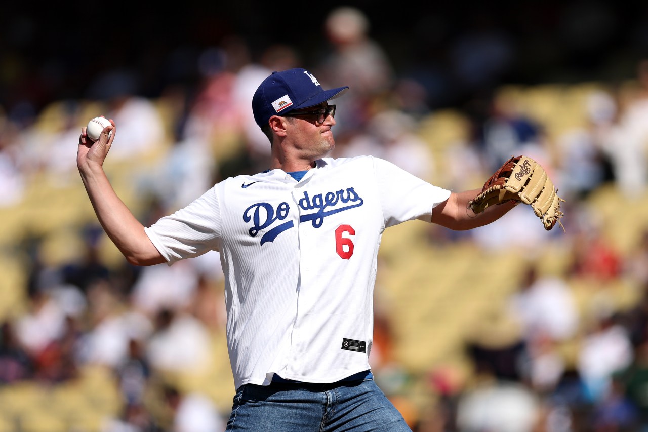 A man in a white Dodgers jersey numbered 6 and a blue Dodgers cap prepares to throw a baseball at Dodger Stadium.