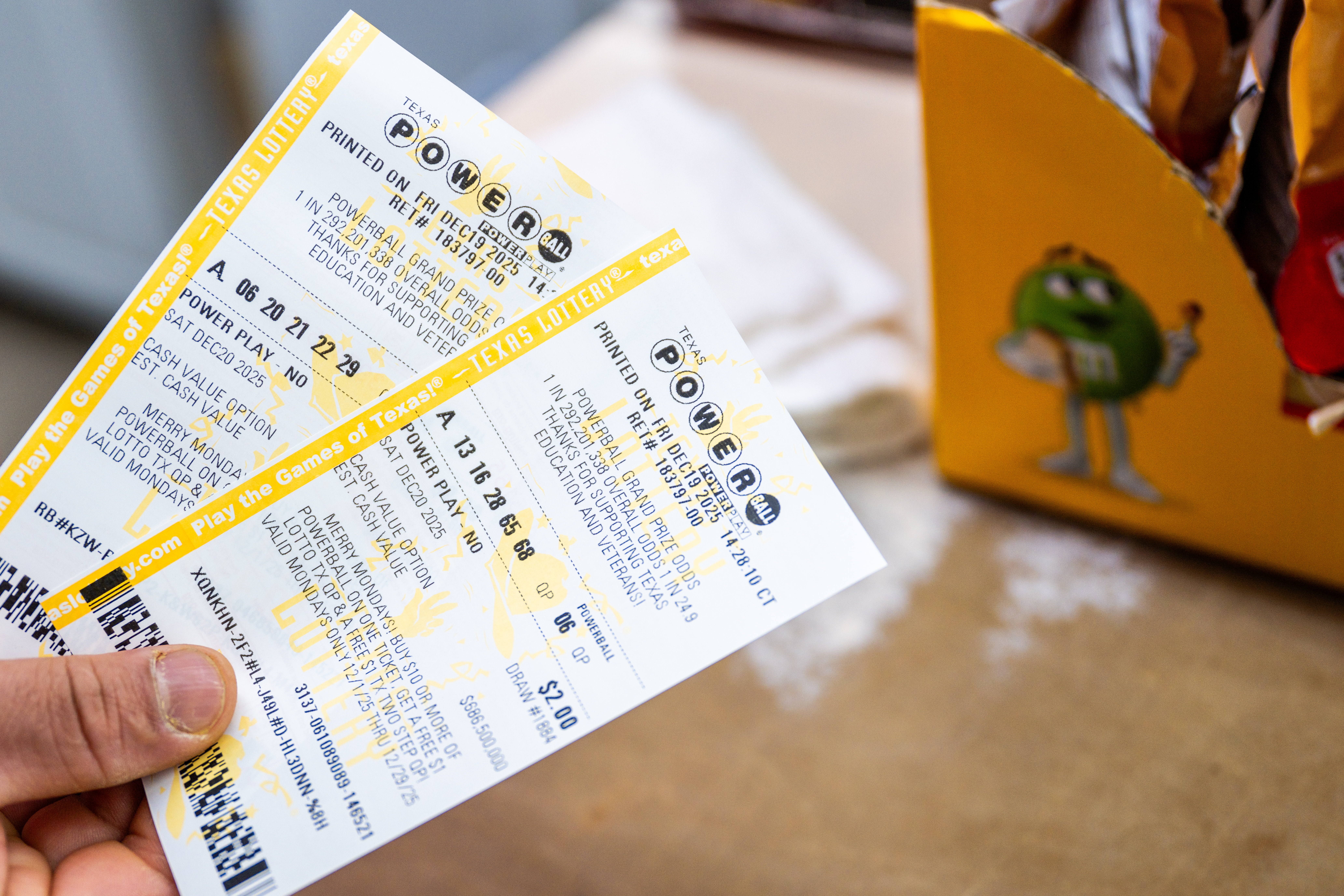 A store clerk holds Powerball lottery tickets at a convenience store in Austin, Texas