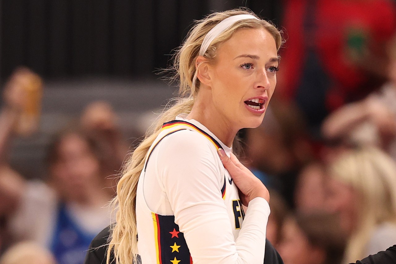 Sophie Cunningham in a white Indiana Fever jersey reacts with mouth open and hand raised to her neck during a game at United Center.