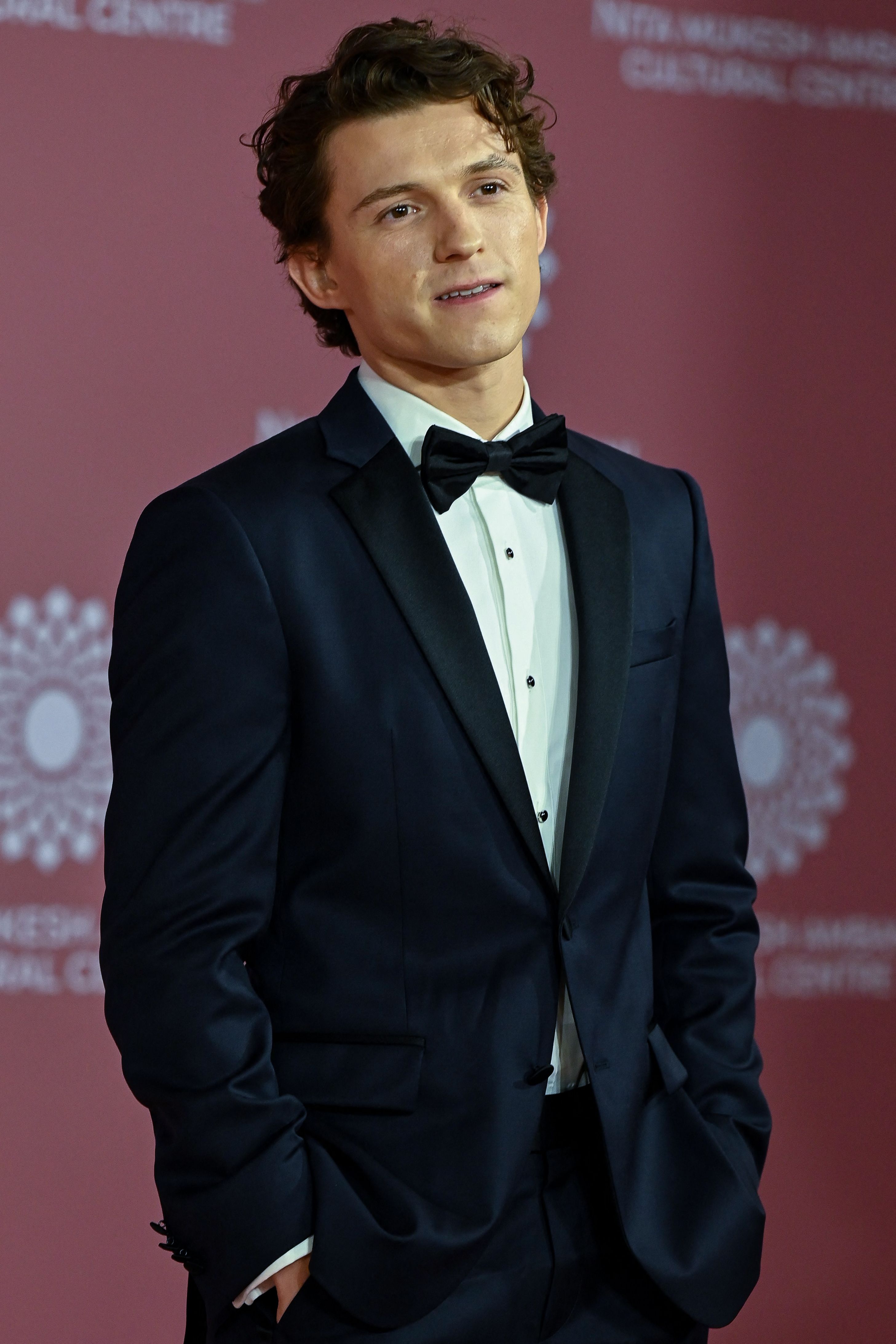 Tom Holland posing for photos at the NMACC inauguration event in Mumbai
