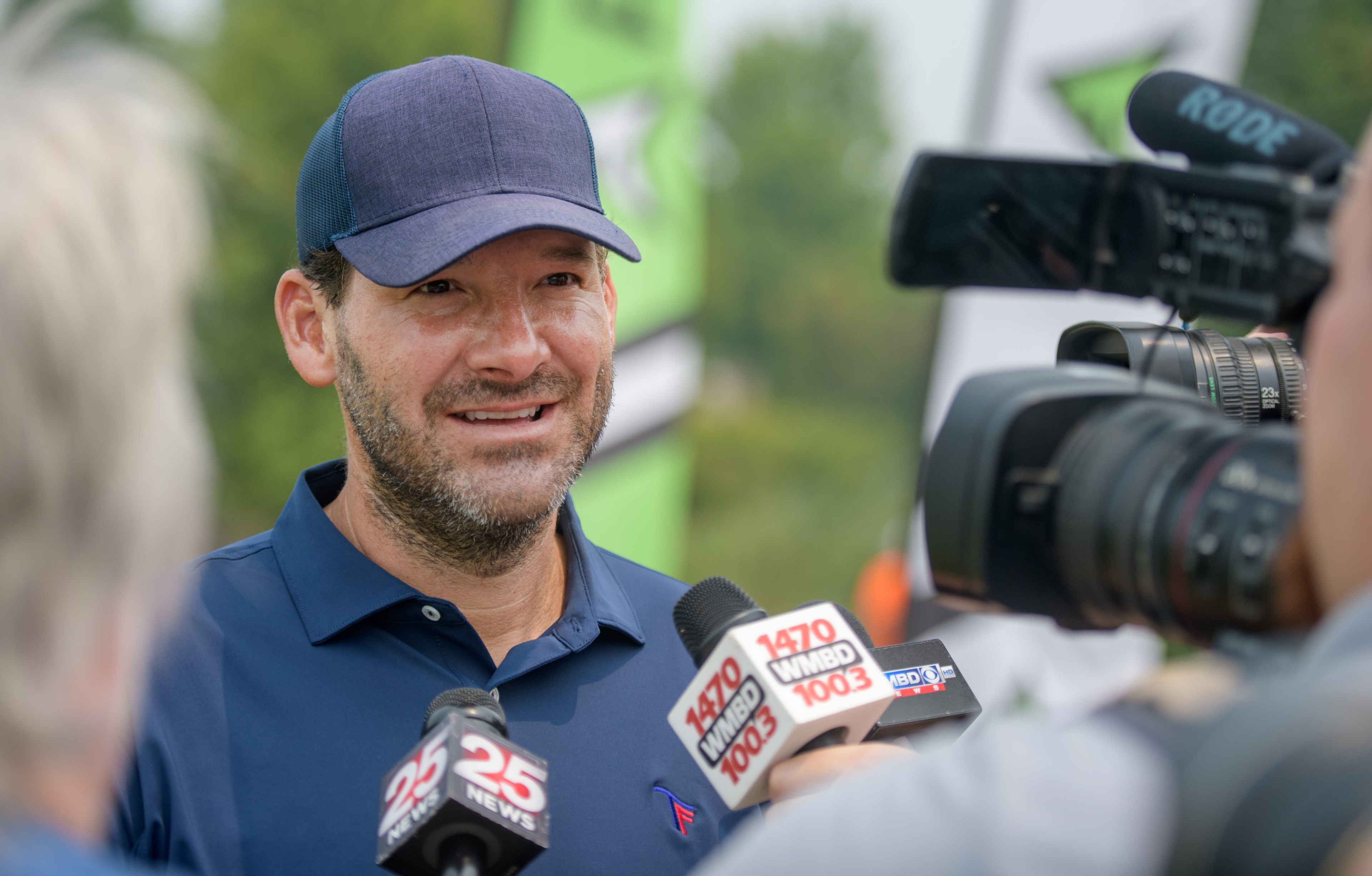 Tony Romo talking with reporters at a golf club event