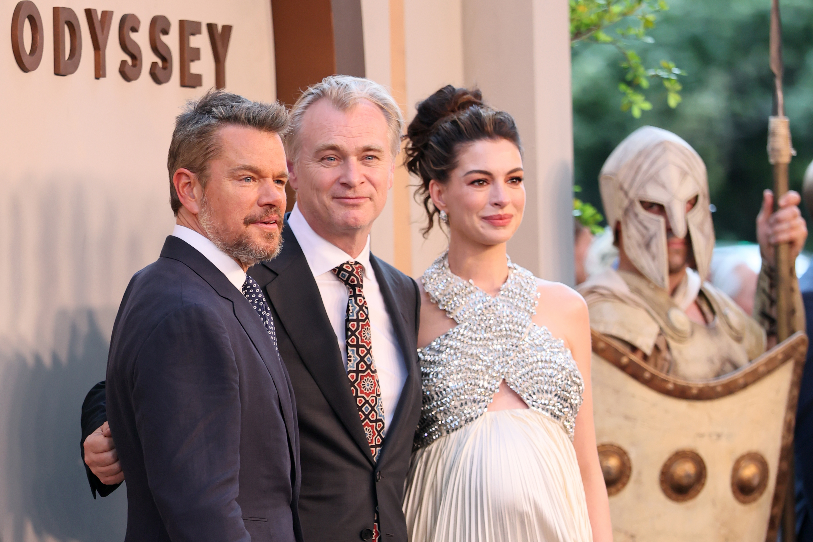 Matt Damon, Christopher Nolan, and Anne Hathaway posing together at The Odyssey New York premiere at AMC Lincoln Square Theater